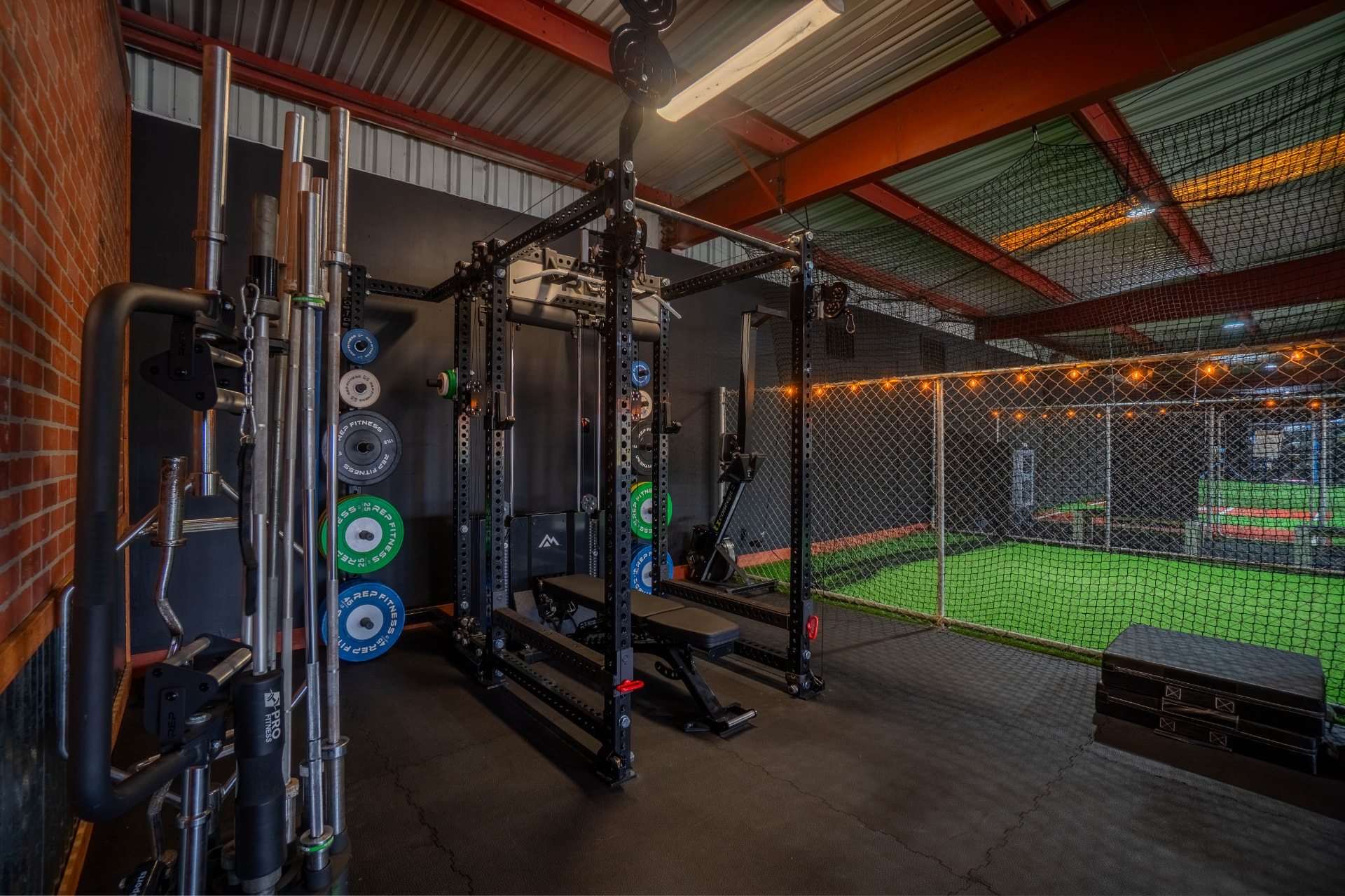 Softball player taking swings inside an indoor cage
